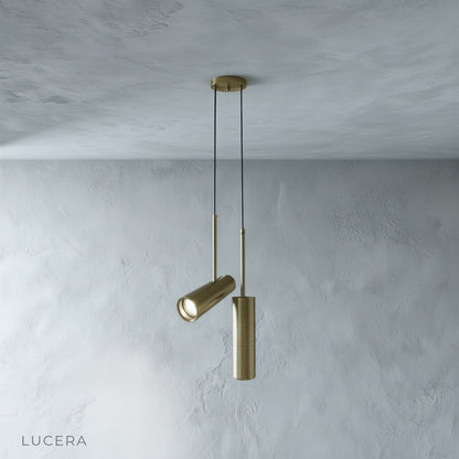 Bistre pendant light in warm gray finish hanging above dining table with soft daylight