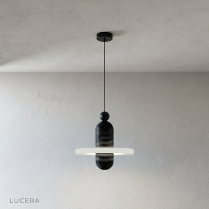 Marianist pendant light hanging at adjustable wire length in minimalist studio