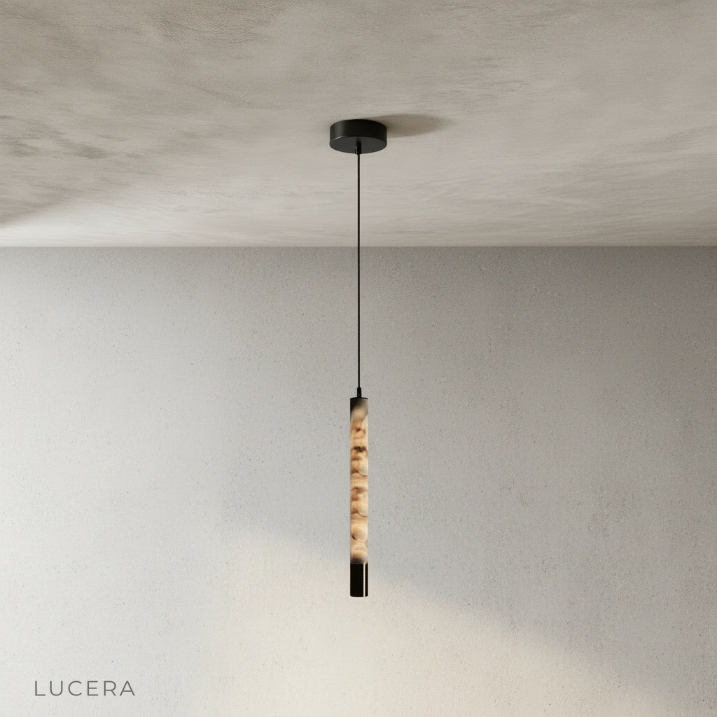 Yseult pendant light hanging above a kitchen island with warm ambient light and dark wood countertop