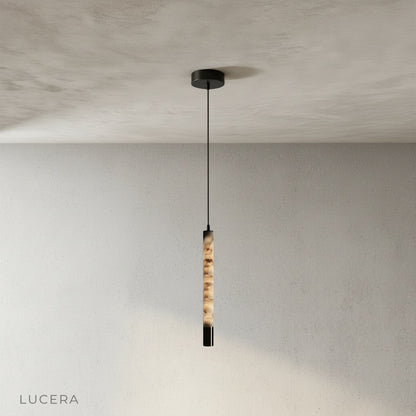 Yseult pendant light hanging above a kitchen island with warm ambient light and dark wood countertop