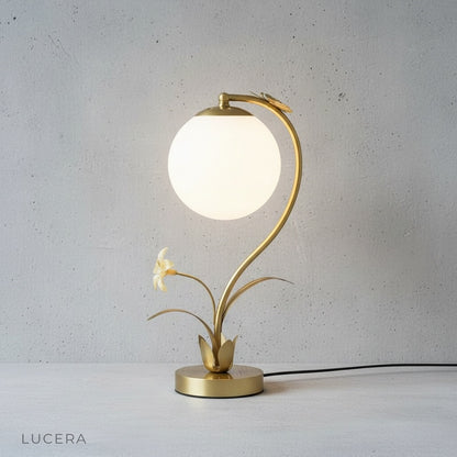 Domenica Table Lamp with frosted glass orb glowing warm light, side angle studio view