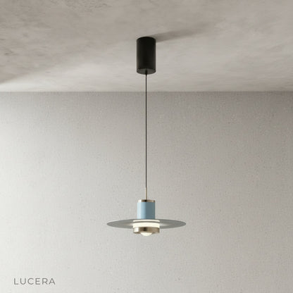 black disc pendant light with warm glow above bar counter in evening setting