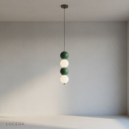 Sogno pendant light with brass accents illuminating a cozy reading nook with soft ambient shadows