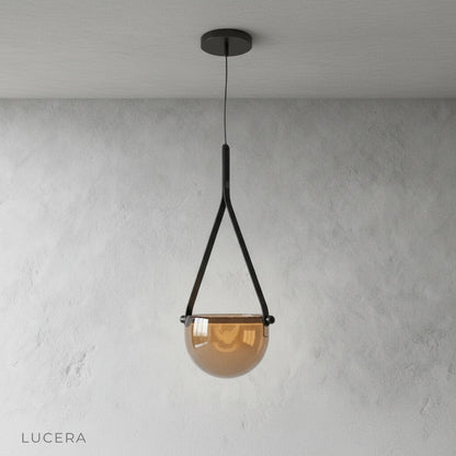 Glimmer leather pendant light hanging above a rustic wooden dining table