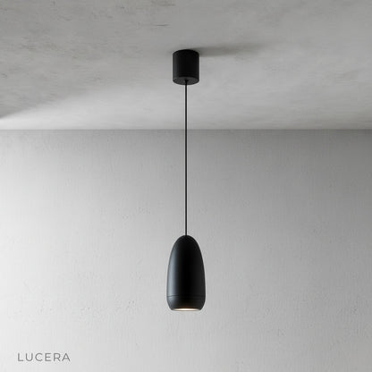 capsule pendant light glowing softly above a dining table in a modern home