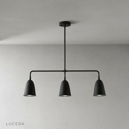 whimsy linear chandelier glowing softly above kitchen island at dusk