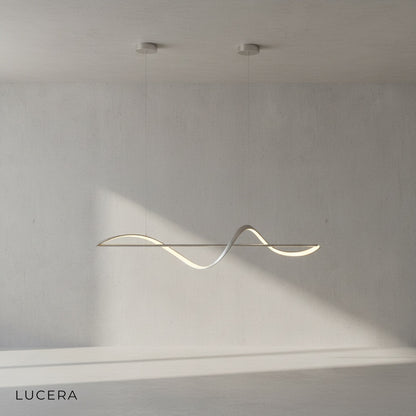 Skuld Wave LED chandelier glowing warm light in minimalist dining room at dusk