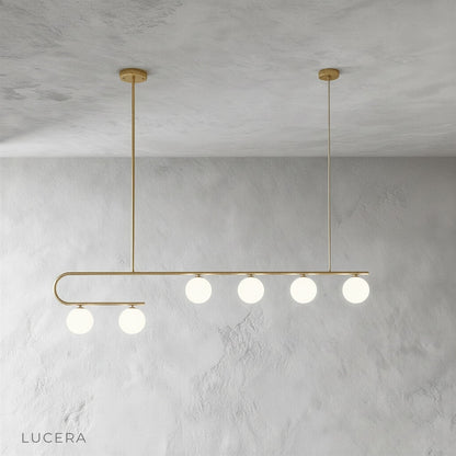 nephrite linear chandelier in matte black finish with five pendant lights over dining table