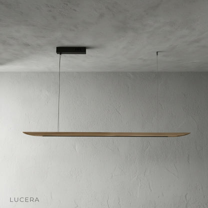 Side angle of the Fauvist pendant light in a studio, highlighting its slim silhouette and matte wood finish