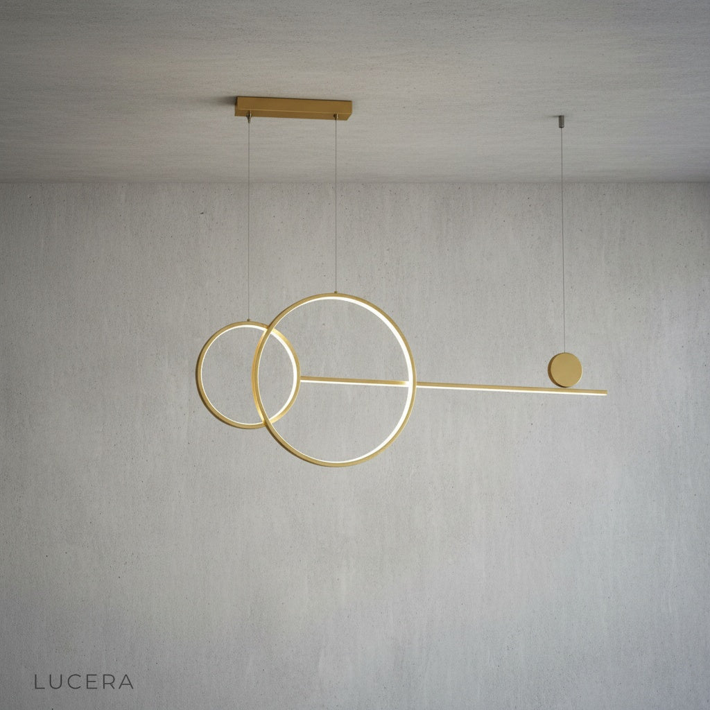 Brumal pendant light gold variant hanging above dining table with soft glow