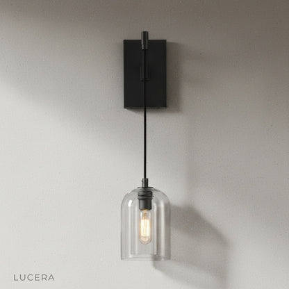 Zuleika Wall Lamp brass finish glowing warmly in cozy reading nook