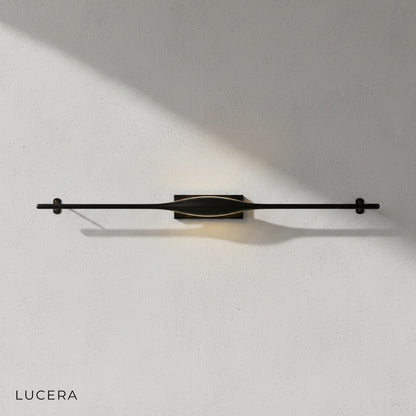 Elan wall lamp above a modern bed in a serene bedroom with soft ambient lighting