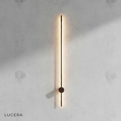 Rinforzando wall lamp in matte black finish against grey studio backdrop