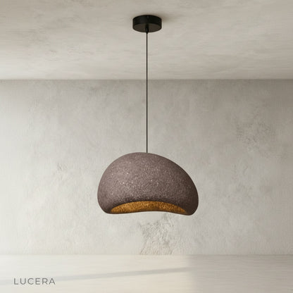 ambient evening shot of sand pendant light glowing in cozy reading corner
