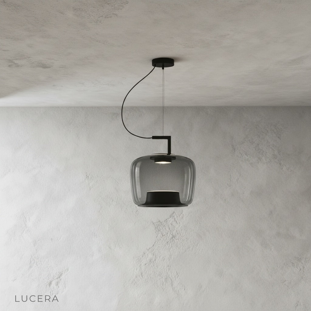 Yardang pendant light trio in amber, grey, and green glass shades arranged in studio row