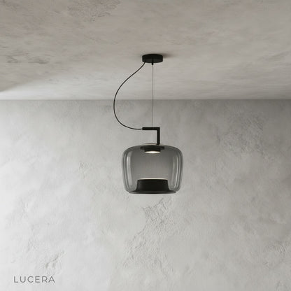 Yardang pendant light trio in amber, grey, and green glass shades arranged in studio row
