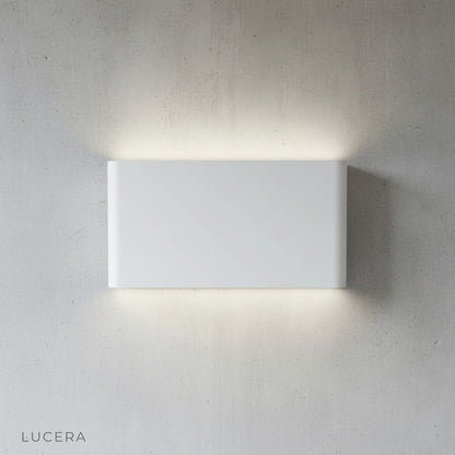 Lucera Cadmium wall lamp mounted on textured concrete wall