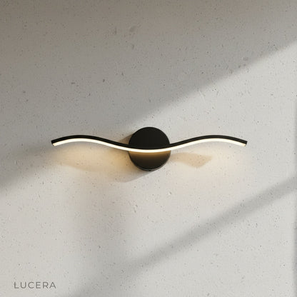 wave-shaped volcanic wall lamp casting warm ambient light in dark moody hallway