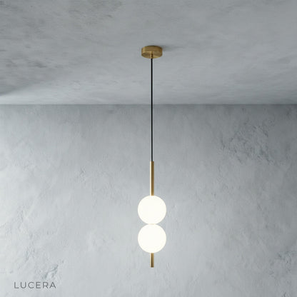 Pair of glass ball pendant lights hanging at different heights in modern hallway