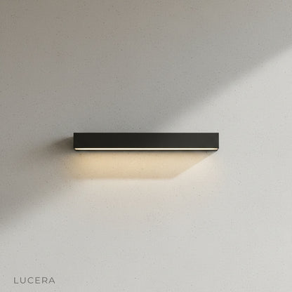 Goccia wall lamp illuminating a cozy garden seating area with warm ambient glow