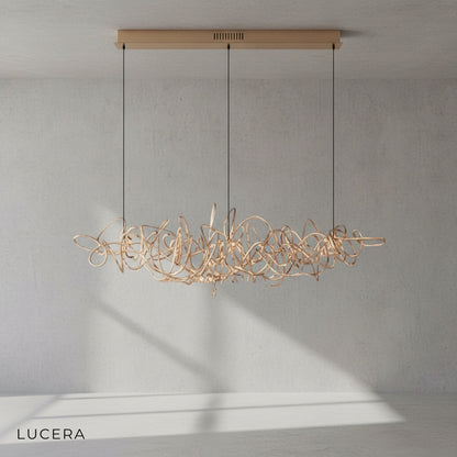 Isabelline rectangle chandelier in rose gold casting soft glow in cozy bedroom with neutral decor