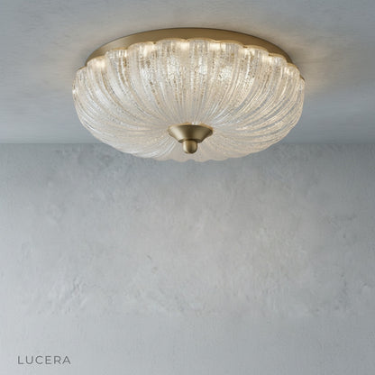 detailed view of glass shade and brass socket on modern ceiling fixture