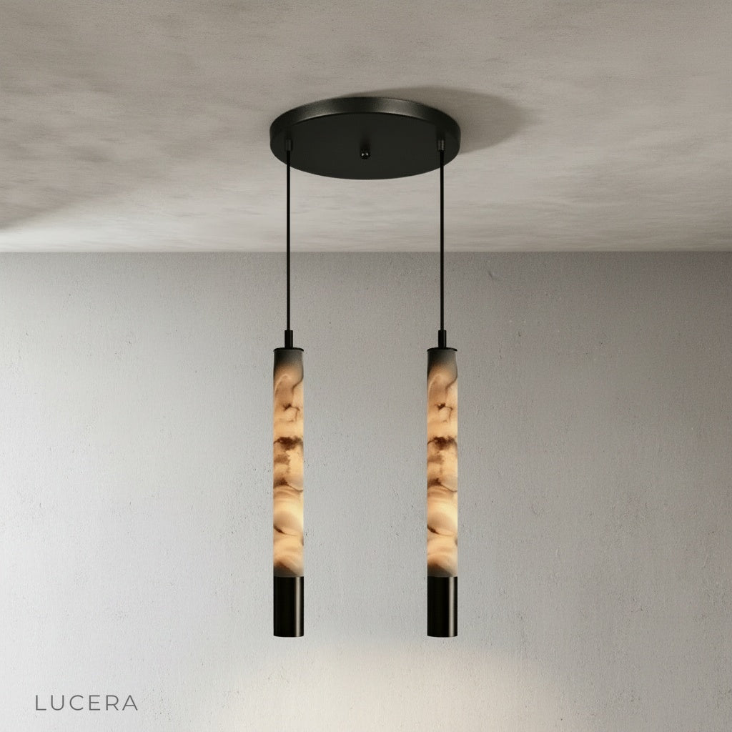 Yseult pendant light illuminated at dusk in a minimalist living room with soft shadows on plaster wall