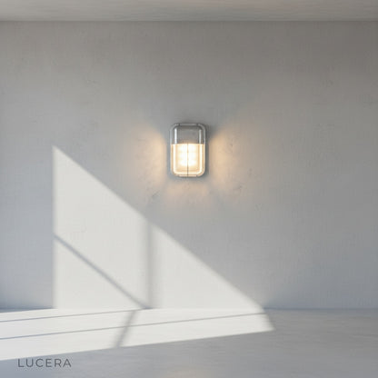 Acolyte outdoor lamp casting light on garden wall with climbing ivy