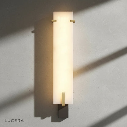 Axonal lamp in dimly lit lounge corner highlighting marble veining and brass-like accents
