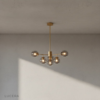 Yett chandelier at dusk in living room with floor lamp and dark wood accents