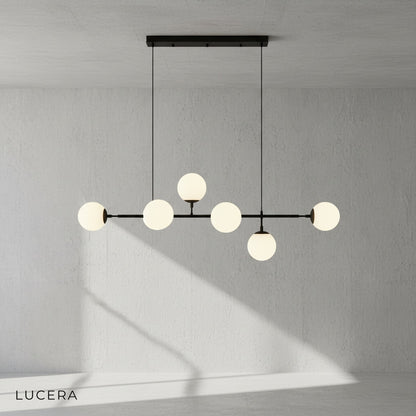 smoke glass ball pendant light suspended from black iron frame in contemporary loft