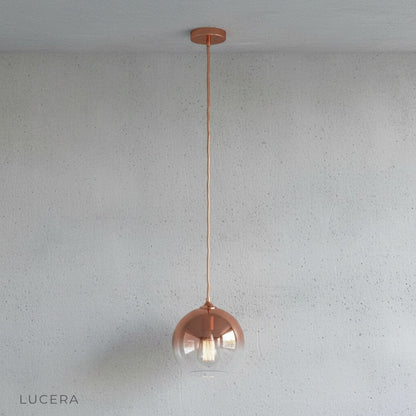 Detail of brass cord and ceiling mount on green gold glass pendant light fixture