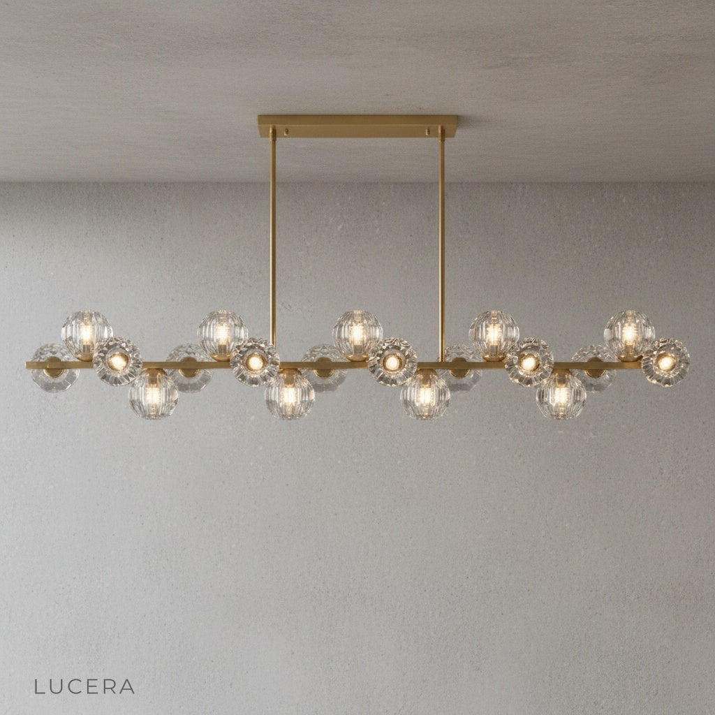 Nighttime shot of Unisono Linear Chandelier casting soft glow in dark living room