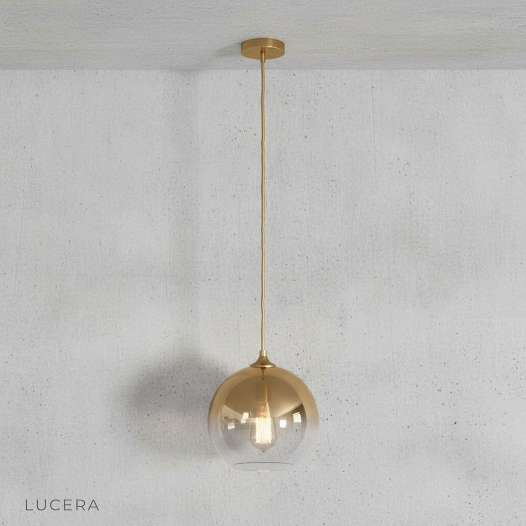 Green gold pendant light casting warm light over a bedside table in cozy bedroom