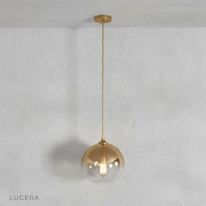 Green gold pendant light casting warm light over a bedside table in cozy bedroom