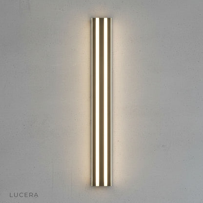 Hesperus wall lamp acrylic shade glowing warmly against dark textured wall