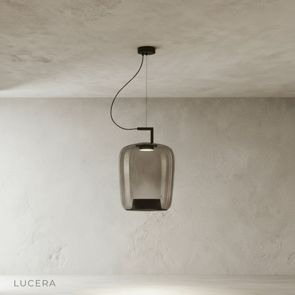 Yardang pendant light illuminated at dusk in cozy reading nook with armchair and bookshelf