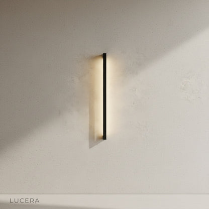 indigo outdoor wall lamp casting soft glow along wooden deck pathway