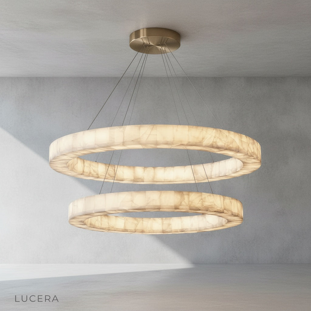 Evening shot of the round alabaster chandelier casting a golden glow over a rustic wooden table