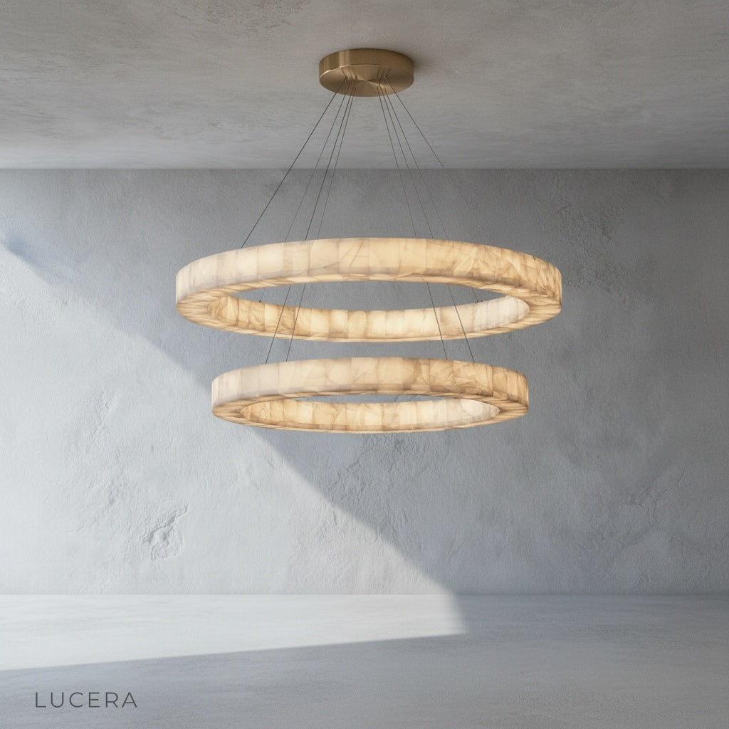 The Lucera chandelier in a high-ceiling entryway, with the stone halo reflecting light on the walls