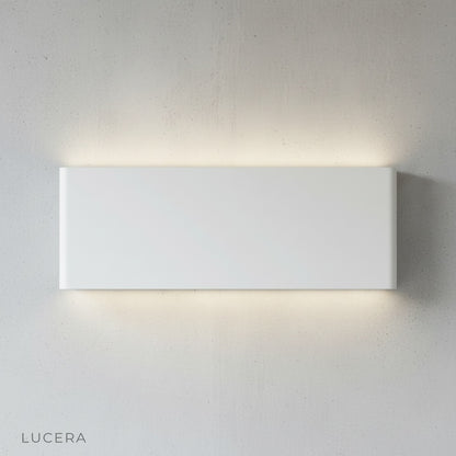 Cadmium wall lamp glowing at dusk on outdoor patio with IP65 waterproofing