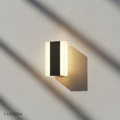 lamp mounted on dark charcoal siding with soft ambient light pool