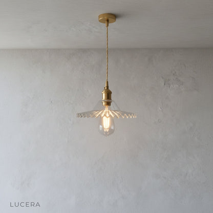 nighttime ambient shot of brass pendant light casting warm glow in dark living room corner