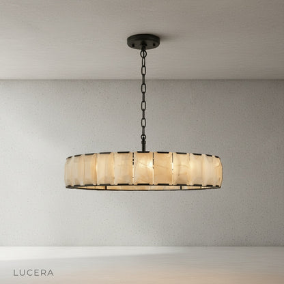 Nighttime lifestyle shot of Vivid Round Alabaster Chandelier casting patterned light on a wall