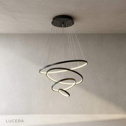 nighttime lifestyle shot of wash chandelier illuminating dark modern stairwell