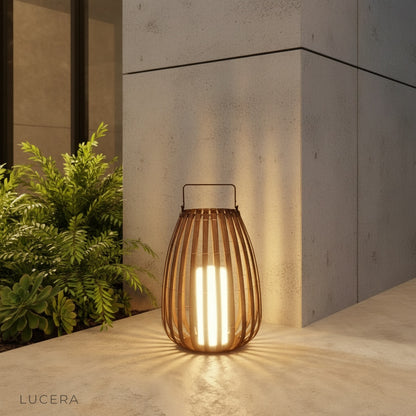 modern black outdoor garden lamp glowing warmly on a patio table at dusk