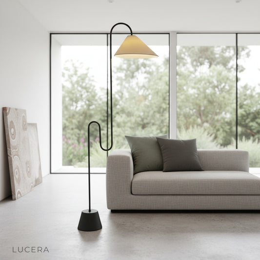 Plaudit Floor Lamp black curved frame glowing warmly in modern living room