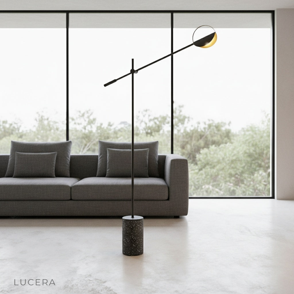 Memento Floor Lamp with terrazzo base and iron frame beside a modern sofa in a bright living room