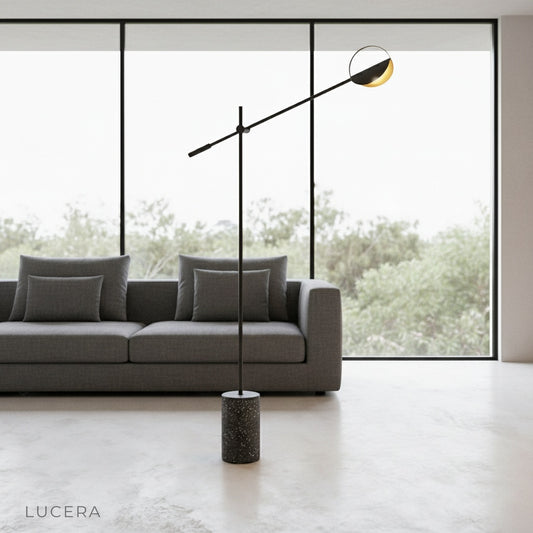 Memento Floor Lamp with terrazzo base and iron frame beside a modern sofa in a bright living room