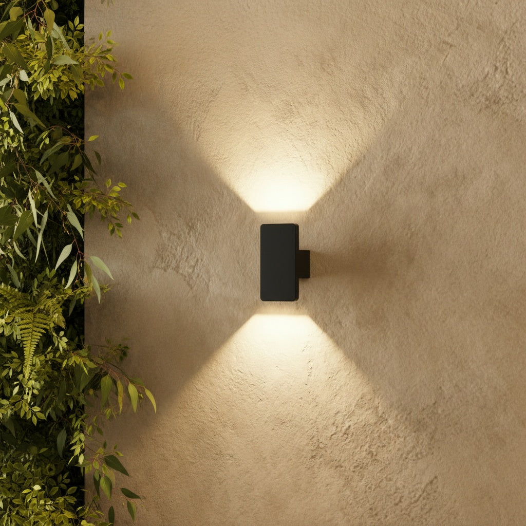 modern black outdoor wall lamp illuminating a cozy patio seating area at dusk